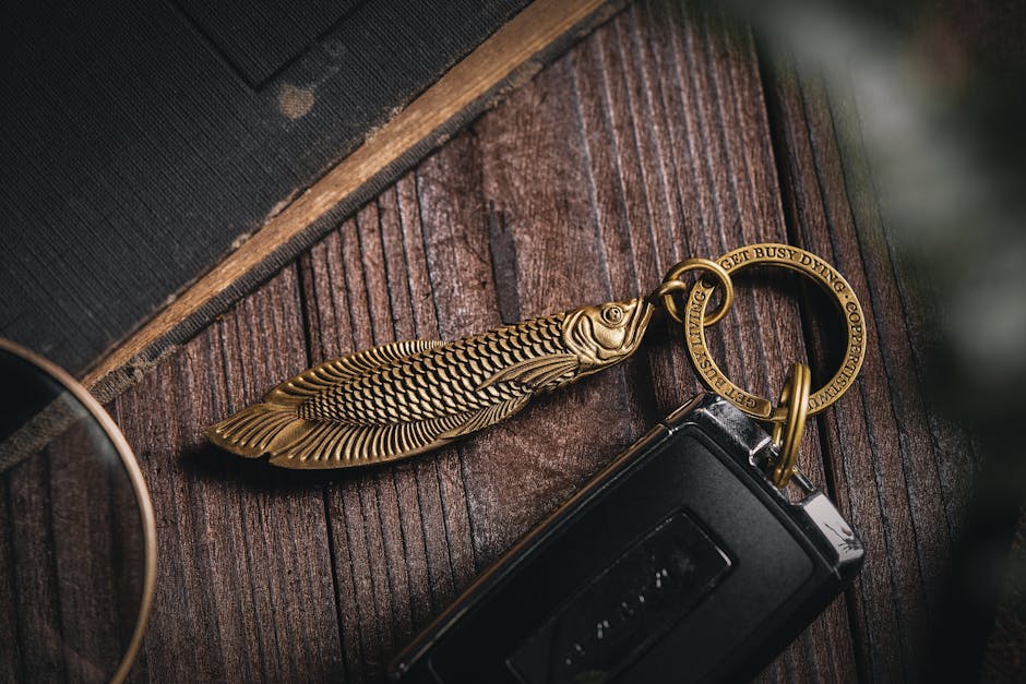 Close-up of a fish-shaped brass keychain on a wooden surface.