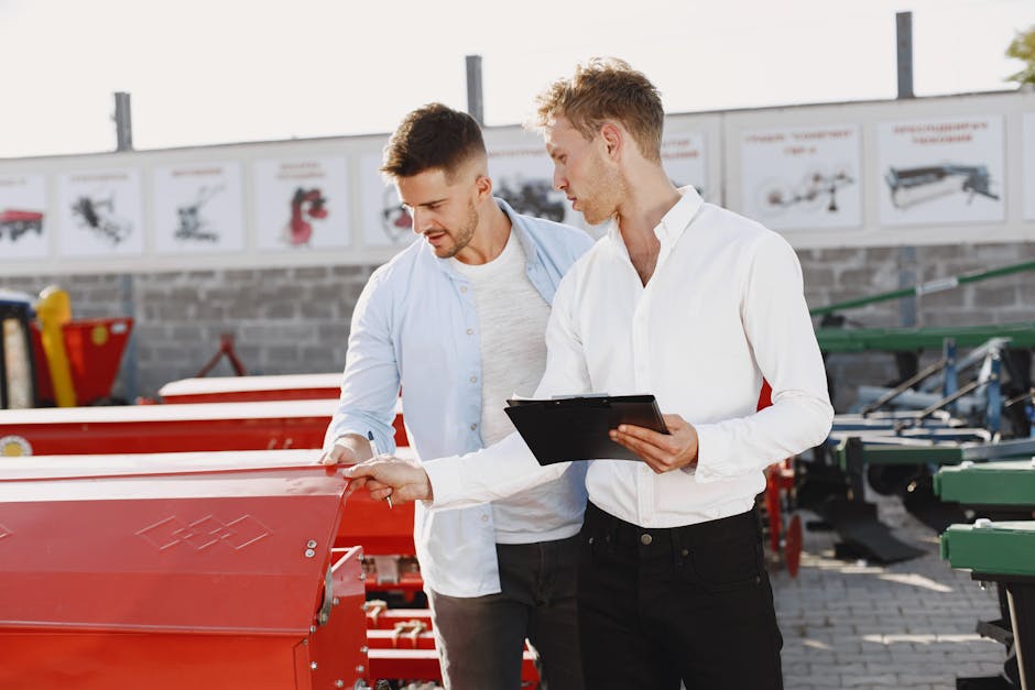 Two men discussing agricultural equipment purchase at a dealership, one holding a clipboard outside.