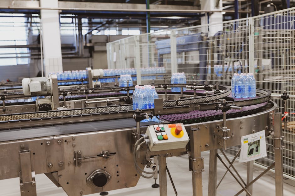 Water bottles being processed on an automated conveyor in a modern factory setting.