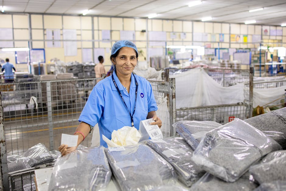 A female worker in blue uniform at a textile factory sorting packaged products.